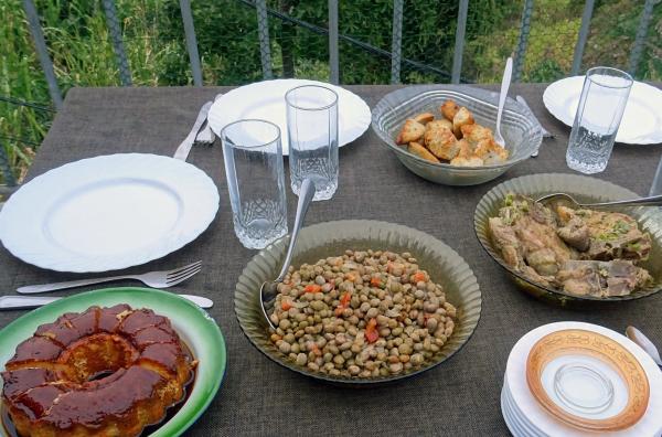 Bild 1 von 5: Gedeckter Tisch mit Bohnensalat, Tarowurzeln und Kaffeepudding