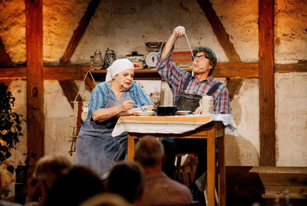 Bild 1 von 1: Aus der Flädlessuppe von Lena (Hillu Stoll) fischt Mattheis (Franz Auber) alte Putzlumpen heraus.