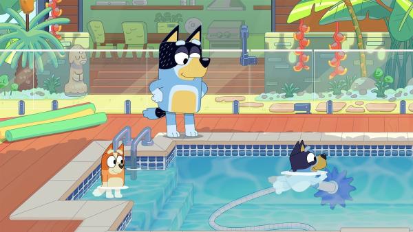 Bild 1 von 3: Bluey und ihr Vater packen die Sachen für den Schwimmbadbesuch ein. Dabei ziehen sie Mama auf, weil sie immer so bedacht darauf ist, ja nichts zu vergessen. Doch als sie beim Schwimmbad ankommen, stellen sie fest, dass ein wenig Planung doch nicht schlecht ist.