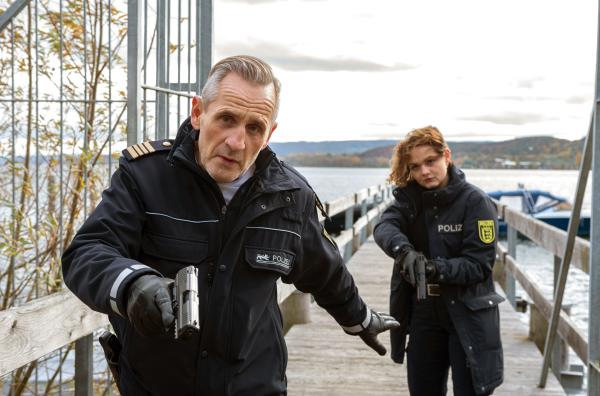 Bild 1 von 3: Paul Schott (Tim Wilde, l.) und Julia Demmler (Wendy Güntensperger, r.) nähern sich bewaffnet auf dem Steg.