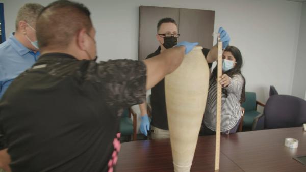 Bild 1 von 7: Officer Acevedo and his team are measuring the length of an ancient Egyptian alabaster vase found in a shipment. (National Geographic)