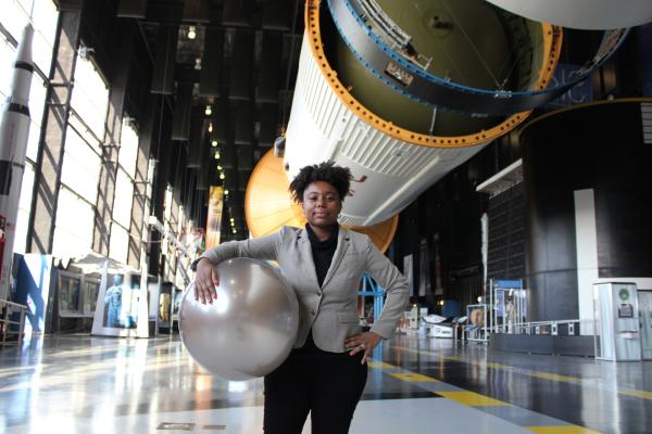 Bild 1 von 4: Die NASA-Ingenieurin Tiera Fletcher vor einer modernen Rakete.