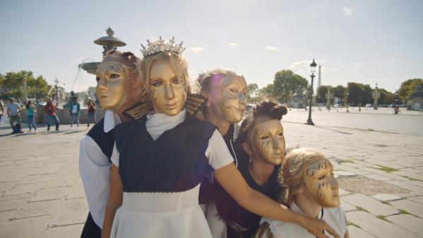 Bild 1 von 5: Lena (Jessica Lord, Mi.) und ihre Tanzgruppe bei einem Überraschungsauftritt mitten in Paris. Um unerkannt zu bleiben tragen alle goldene Masken vor dem Gesicht.