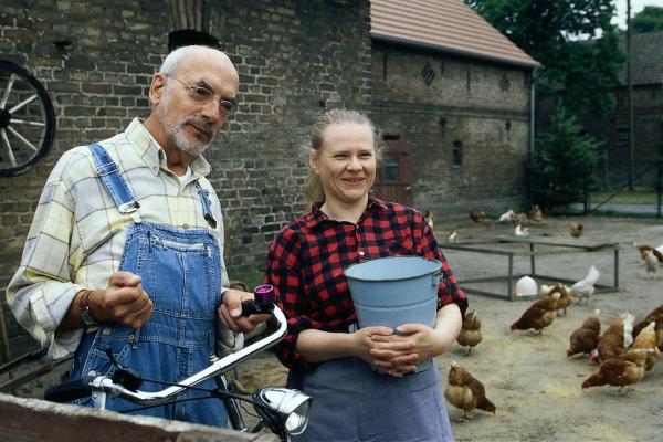Bild 1 von 4: Natürlich gibt es auf einem Bauernhof Spatzen. Die Bäuerin (Hildegard Schröter, r.) zeigt Peter (Peter Lustig, l.), dass die Spatzen gerne den Hühnern die Körner wegfressen.