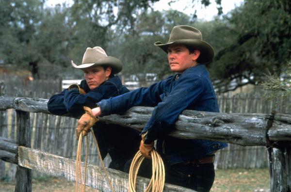 John Grady Cole (Matt Damon, li.) und sein Freund Lacey Rawlins (Henry Thomas, re.) haben auf einer großen mexikanischen Ranch angeheuert. Zwei Männer mit Cowboyhut und Arbeitsleidung stehen mit Lassos an einer Koppel.