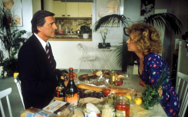 Bild 1 von 2: Noch ahnt Ilse Haslbeck (Ilse Neubauer) nichts von dem Abkommen, daß ihr Josef (Helmut Fischer) als Hausmann mit Frau Brandl hat: Diese erledigt dem arbeitsscheuen Josef alle Arbeiten im Haushalt.