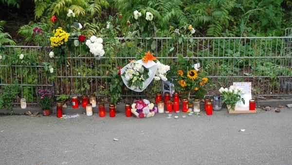 Bild 1 von 5: Passanten und Trauernde haben Blumen am Tatort abgelegt und Kerzen angezündet. Der Fall erschüttert die gesamte Stadt.