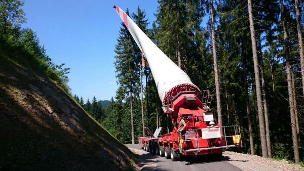 Bild 1 von 2: Ein Rotorblatt für eine Windkraftanlage muss auf einen Berg im Schwarzwald transportiert werden. Das Problem: Das Rotorblatt ist mit 46 Metern zu lang für die engen Kurven und Ortsdurchfahrten.