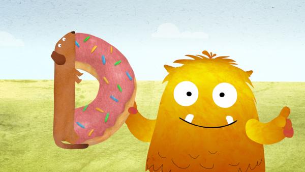 Bild 1 von 2: Nitso sucht das D und findet dabei einen Dackel, der von einem Donut abbeißt.