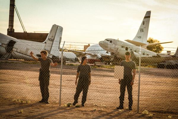 Bild 1 von 6: Die drei Kamerad*innen Guus Walema (Soy Kroon, l.), Leyla Demir (Sinem Kavus, M.) und Rutger de Man (Josha Stradowski, r.) entdecken hunderte Flieger in der Wüste. Sie bezweifeln, dass sie als niederländische Soldaten für die USA unentbehrlich sind.