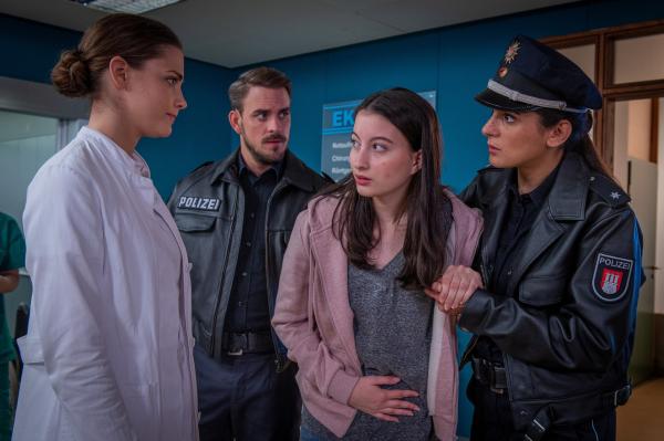 Bild 1 von 8: Pinar (Aybi Era, r.) und Kris (Marc Barthel, M.) bringen die schwangere Elina (Mila Böhning, 2.v.r.) zu Dr. Grünberg (Laura Berlin, l.) ins EKH.