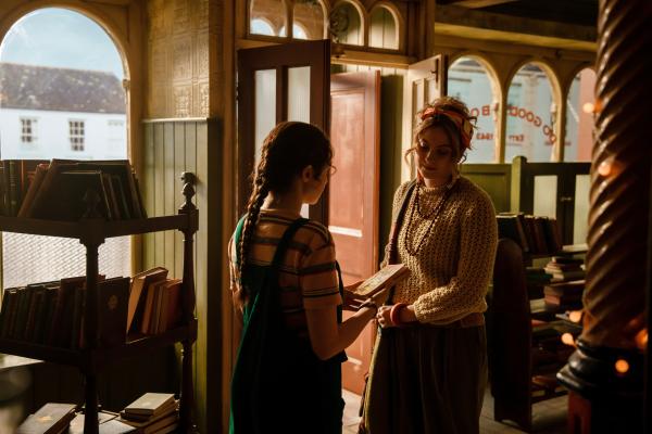 Bild 1 von 4: Addie (Lola Blue, links) will den verlassenen Buchladen auf Vordermann bringen und für ganz Juniper zugänglich machen. Ihre Schwester Keedie (Georgia De Gidlow) bringt ihr auch ein Buch für den Verkauf vorbei.