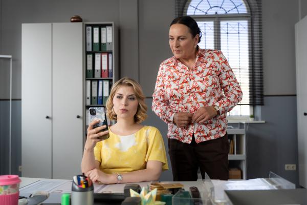 Bild 1 von 6: Frau Lange (Sarah Thonig, l.) und Frau Grasegger (Ursula Maria Burkhart, r.) verfolgen den Livestream, den die Influencerin Jana Serana live vom Tatort postet.