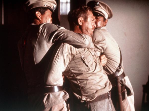 Bild 1 von 1: Der aufsässige Sträfling Henri Charrière alias Papillon (Steve McQueen) wird von Wärtern niedergerungen.