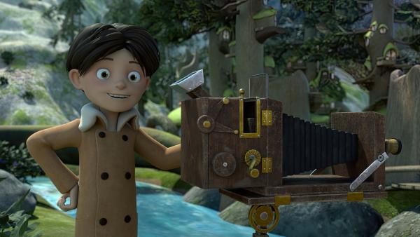 Bild 1 von 3: Stolz präsentiert Klincus den Frondosianern seinen selbstgebauten Fotoapparat, mit dem er ein Portrait der Königin anfertigen will.