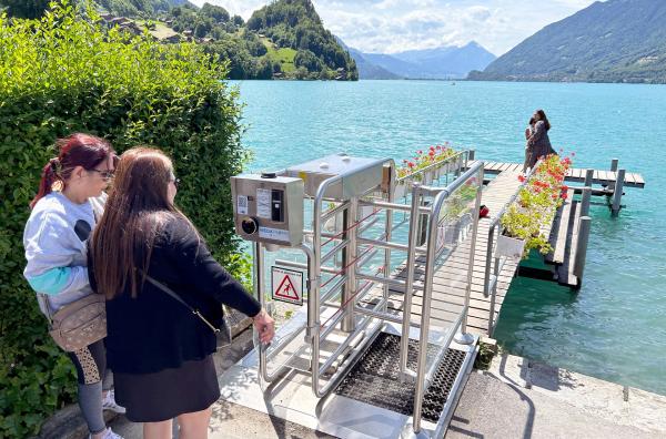 Bild 1 von 3: Um dem Massentourismus im Schweizer Dorf Iseltwald entgegenzuwirken, wurde ein Bezahl-Drehkreuz vor dem Steg aufgebaut, auf den die Fans einer Netflix-Serie pilgern.