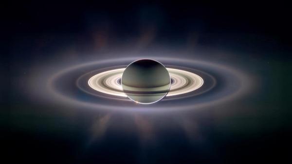 Bild 1 von 3: Der Planet Saturn in eindrucksvoller Gegenlichtaufnahme - seine leuchtenden Ringe offenbaren die filigrane Schönheit kosmischer Strukturen.