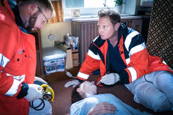 Bild 1 von 8: Dr. Haase (Fabian Harloff, r.) und sein Kollege (Komparse) finden Lotte Uhland (Hiltrud Hauschke, M.) in ihrer Wohnung vor. Haase diagnostiziert einen Schlaganfall und möchte, dass die alte Dame sofort ins EKH gebracht wird.