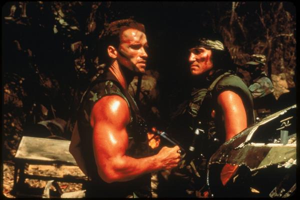 Bild 1 von 2: Major Dutch Schaefer (Arnold Schwarzenegger) helps Poncho (Richard Chaves) in PREDATOR.
