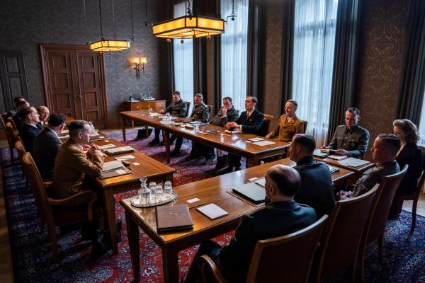 Bild 1 von 13: Im Konferenzraum: Die Besprechung beginnt. Von hinten rechts nach links: Dr. Rudolf Lange (Frederic Linkemann), Dr. Eberhard Schöngarth (Maximilian Brückner), Dr. Josef Bühler (Sascha Nathan), Dr. Georg Leibbrandt (Rafael Stachowiak), Dr. Alfred Meyer (Peter Jordan), Adolf Eichmann (Johannes Allmayer), Ingeburg Werlemann (Lilli Fichtner), Heinrich Müller (Jakob Diehl), Reinhard Heydrich (Philipp Hochmair), Otto Hofmann (Markus Schleinzer),  Dr. Gerhard Klopfer (Fabian Busch), Friedrich Wilhelm Kritzinger (Thomas Loibl), Dr. Wilhelm Stuckart (Godehard Giese), Martin Luther (Simon Schwarz), Erich Neumann (Matthias Bundschuh), Dr. Roland Freisler (Arnd Klawitter).