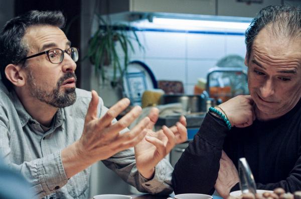 Bild 1 von 2: Eine Wohngemeinschaft diskutiert darüber, ob sie sich einen neuen Staubsauger anschaffen: ein real-satirischer Film über Wohlstands-Probleme, Demokratie und Gruppendynamik, in der sich Poesie, Banalität und Humor vermischen.