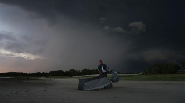 Bild 1 von 1: Ein aufkommender Sturm macht Samuel beim Zeltaufbau in Nebraska zu schaffen.