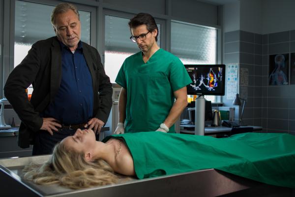 Bild 1 von 7: Arthur Bauer (Gerd Silberbauer, l.) und Dr. Weissenböck (Florian Odendahl, r.) sprechen über die Leiche von Fabienne Lüders (Michelange Maté, vorne).