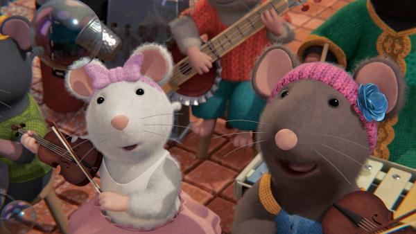 Bild 1 von 3: Ella (links) und Sarah (rechts) spielen mit im Orchester. Erstaunt bemerken sie, wie ein neuer Klang im Orchester ertönt und Seifenblasen über ihren Köpfen schweben.