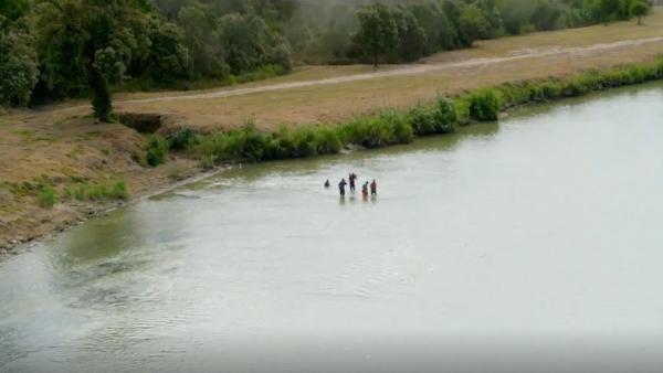 Bild 1 von 3: Mehrere Menschen waten durch den Rio Grande und riskieren ihr Leben, um die Grenze zu überwinden - ein gefährlicher Weg, den viele aus Verzweiflung auf sich nehmen.