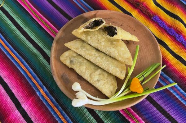Bild 1 von 2: Auf der Insel Flores in der Mitte des Sees Petén Itzá bereitet Laetitia gefüllte Empanadas aus Mais-Teig zu. Als Beilage gibt es Pilze aus dem Regenwald mit Paprika und Schnittlauch.