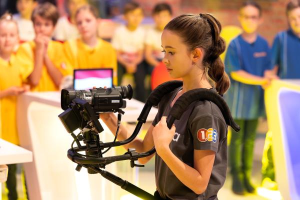 Bild 1 von 11: Kamerakind Fianna im Einsatz mit einer professionellen Kamera.
