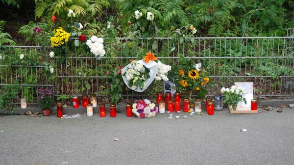 Bild 1 von 5: Passanten und Trauernde haben Blumen am Tatort abgelegt und Kerzen angezündet. Der Fall erschüttert die gesamte Stadt.