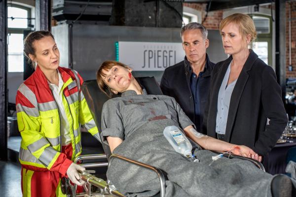 Bild 1 von 4: Dr. Bartholdy (Anne Roemeth, l.) kümmert sich um Lena Biehl (Sophie Lutz, 2.v.l.), deren Zwillingsschwester getötet wurde. Jan Maybach (Marco Girnth, 2.v.r.) und Ina Zimmermann (Melanie Marschke, r.) können im Moment noch nicht mit ihr sprechen.