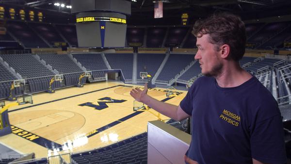 Bild 1 von 4: Kosmologe Dragan Huterer erklärt Mikrowellen mit Basketballspielern in einer Sporthalle.