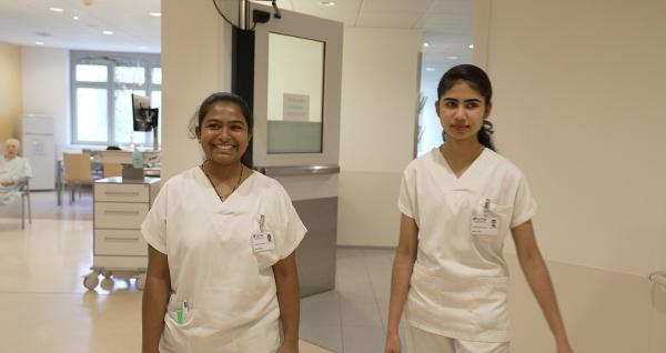 Bild 1 von 13: Überalterung der Gesellschaft, bevorstehende Pensionswelle und fehlende Fachkräfte: Die Pflegekrise in Ländern wie Österreich ist in aller Munde. Lösungsideen entstehen mitunter an überraschenden Orten: Unter der Leitung ihres Provinzials Saji Mullankuzhy entwickelte die österreichische Ordensprovinz der Barmherzigen Brüder ein Programm, um in Indien ausgebildete Pflegekräfte in Österreichs Spitäler zu holen. Doch die Hürden sind groß. Peter Beringer hat die jungen Pflegerinnen getroffen und sie einen Teil des Weges und bei ihrer Arbeit in Österreich begleitet. Im Bild: Schon seit bald einem Jahr am Krankenhaus der Barmherzigen Brüder in Eisenstadt - Mary Sneha und Megha Biju.