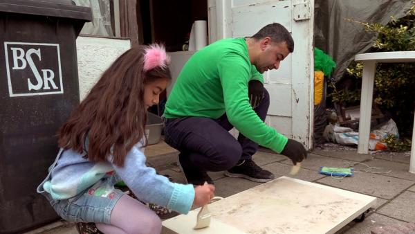 Bild 1 von 4: Mehmet und seine Tochter Delila lackieren ein Rollbrett