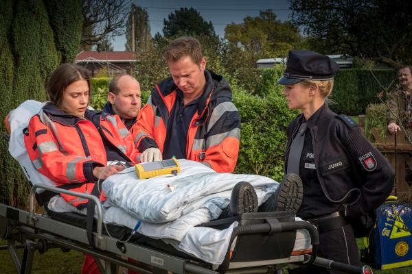 Bild 1 von 11: Dr. Haase (Fabian Harloff, 2.v.r.) kümmert sich um seine Kollegin Dr. Grünberg (Laura Berlin, l.), die von einem Patienten angegriffen wurde. Franzi (Rhea Harder-Vennewald, r.) befragt sie zu dem Vorfall.