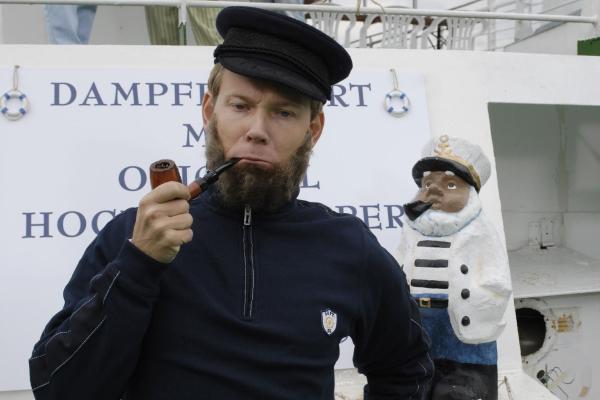 Bild 1 von 4: Der Ausflugsdampfer-Kapitän Mathias (Mathias Schlung) verwechselt das Deck mit dem Dock, das Steuerbord mit dem Steuerrad und Knoten mit Schleifen. Die alten Seebären sind halt auch nicht mehr das, was sie mal waren - oder ist alles nur Seemannsgarn...?