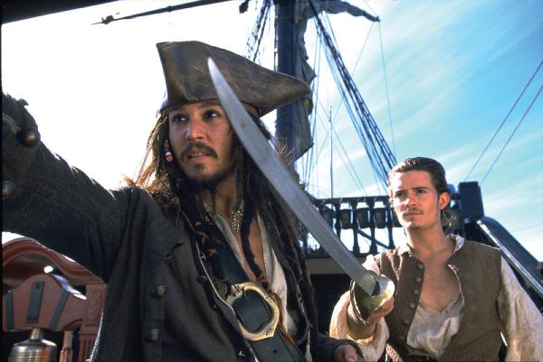 Bild 1 von 69: Kristallklar blitzt das Meerwasser in der karibischen Sonne. Hier, wo Freiheit, Abenteuer und Lebenslust förmlich in der Luft liegen, fühlt sich der verwegene und charmante Haudegen Captain Jack Sparrow (JOHNNY DEPP) zu Hause. Sein bis dahin paradiesisches Leben erhält einen jähen Dämpfer, als der durchtriebene Captain Barbossa (GEOFFREY RUSH) sein stolzes Schiff, die BLACK PEARL, in seine Gewalt bringt und mit ihr die Hafenstadt Port Royal überfällt, wo er die bildschöne Tochter des Gouverneurs, Elizabeth Swann (KEIRA KNIGHTLEY), entführt. Der junge Waffenschmied Will Turner (Orlando Bloom) mit mysteriöser Herkunft liebt besagte Tochter des Gouverneurs und möchte die Liebe seines Lebens retten - wenn es sein muss auch mithilfe des exzentrischen Captain Jack Sparrow. Zwar ist Captain Jack durch Wills Mithilfe im Gefängnis gelandet, aber die beiden Männer haben nun ein ähnliches Ziel: Will möchte Elizabeth retten und Sparrow sein Schiff \