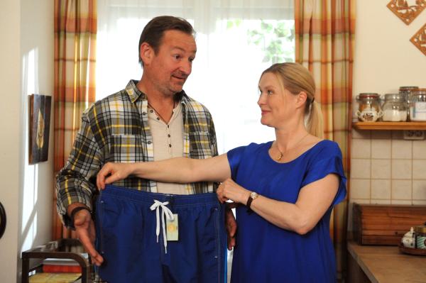 Bild 1 von 8: Vera (Sybille Waury) zeigt Gregor (Holger Matthias Wilhelm) seine neue, moderne Badeshort, die sie extra für ihn gekauft hat.