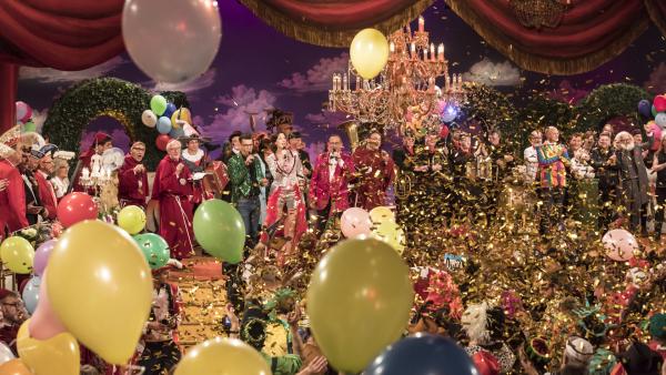 Bild 1 von 2: Reportage von den Vorbereitungen der Fastnacht, vom roten Teppich in Veitshöchheim, hinter den Kulissen der TV-Livesendung und von der After-Show-Party. Vorabbild aus 2018: Das große Finale mit allen Interpreten auf der Bühne.