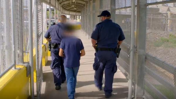 Bild 1 von 3: Ein allein reisender Junge wird von Grenzbeamten über die internationale Brücke geführt. Widersprüche in seiner Geschichte lassen bei den Beamten die Alarmglocken läuten.