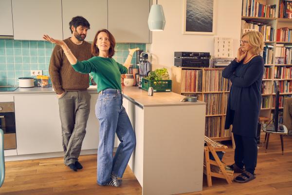 Bild 1 von 4: Nina (Lavinia Wilson, M.) präsentiert ihrer Mutter Ini (Johanna Gastdorf, r.) die neue Wohnung, die sie und Jannos (Jasin Challah, l.) durch die Mitgliedschaft in einer Baugruppe beziehen konnten.
