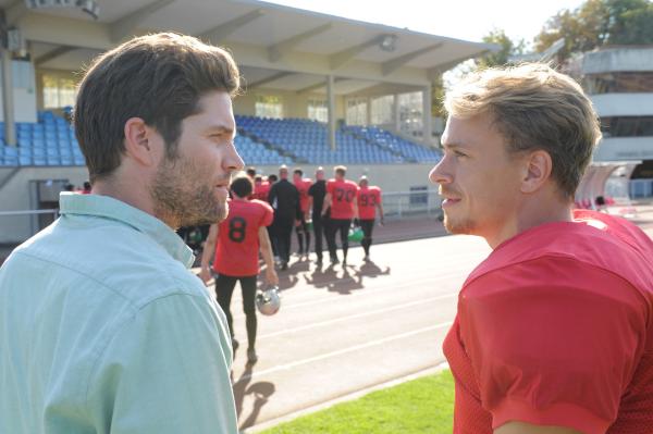 Bild 1 von 6: Jo Stoll (Peter Ketnath, l.) befragt Phil Poschner (Matthias Ludwig, r.), der illegale Dopingmittel vertreibt. Die anderen Footballspieler (Komparsen) sind auf dem Weg in die Kabinen.