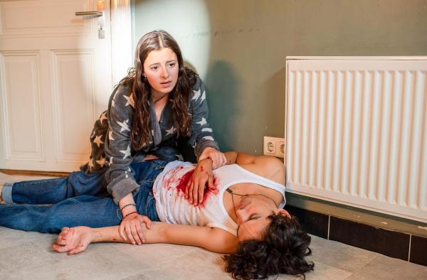 Bild 1 von 5: Im Bild: Carina (Mia Kasalo, l.) kniet neben ihrem toten Freund Enzo (Jasper Engelhardt, r.). Während Carina hinten in der Küche das Frühstück zubereitete, wurde er vorne an der Haustür erstochen.
