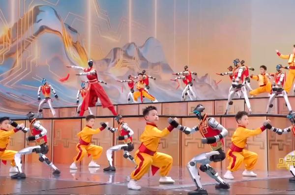 Bild 1 von 1: Am 16. Februar 2026 zeigte das chinesische Staatsfernsehen eine Zukunftsvision des Regimes: Zwölf humanoide Roboter führen mit Kindern Kampftechniken aus.