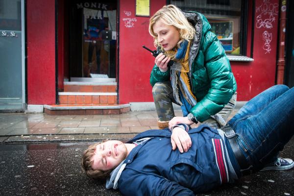 Bild 1 von 9: Melanie (Sanna Englund) ruft einen Notarztwagen. Dennis (Tobias Schenke) hat bei einer Schlägerei mit Paulus den Kürzeren gezogen.