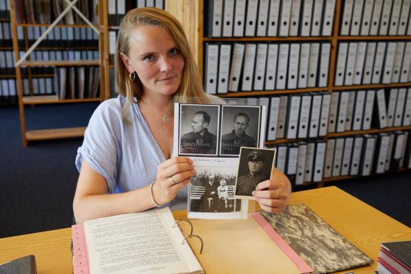 Maria Holzgrewe mit Familienfotos, die ihren Urgroßvater Wilhelm Dreimann zeigen - darunter auch ein Bild mit seiner Tochter. Dreimann wurde von den Häftlingen
