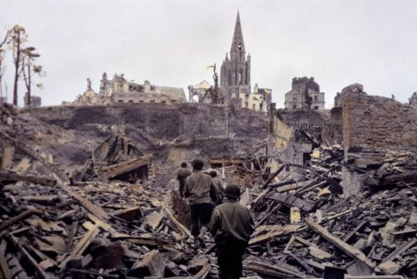 Bild 1 von 3: Eine US-Infanteriepatrouille bahnt sich einen Weg durch die Ruinen von Saint Lô. Die französische Stadt wird im Zweiten Weltkrieg zu 95 Prozent zerstört.
