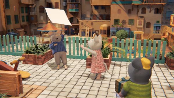 Bild 1 von 3: Sam (l.) und Julia (M.) versuchen verzweifelt ihr selbst gemaltes Bild einzufangen, das der Wind gerade wegweht. Es ist ihr Geburtstagsgeschenk für Ella. Tonio (r.) schaut gespannt zu.